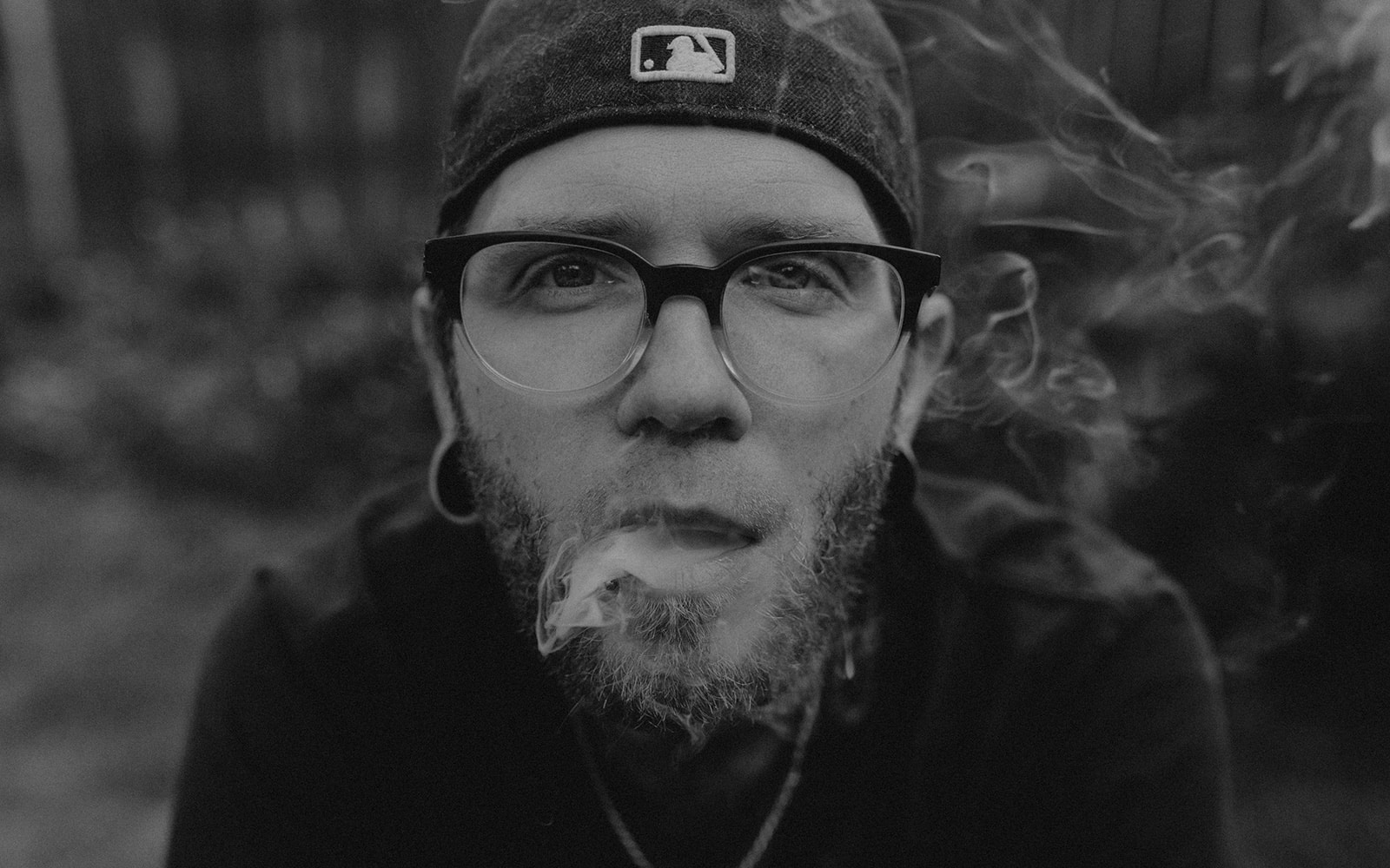 young disabled man with multiple sclerosis blowing cannabis smoke in the PNW